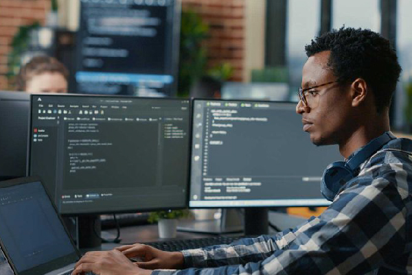 persona haciendo programación en una ocmputadora con varios monitores